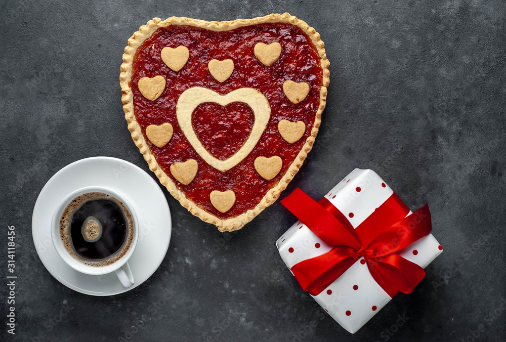 coffee, heart-shaped cake, a gift with a red ribbon for Valentine's Day on  stone background, with copy space for your text. breakfast concept on  saint's day  Valentine.