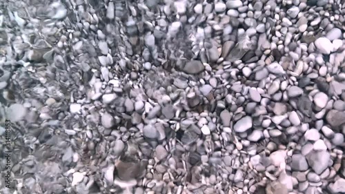 Sea water reflecting on beach rocks. Sea waves footage. Summer vacation concept