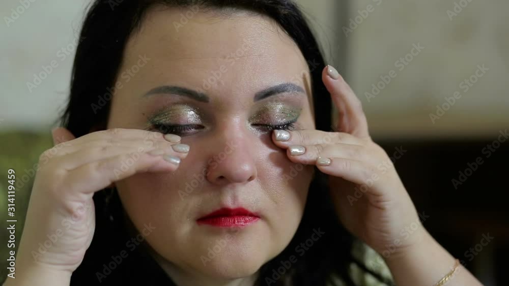 A crying woman wipes tears from her eyes. Close-up A crying woman wipes tears from her eyes. Close-up