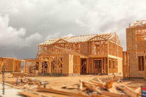 Wood Home Framing Abstract At Construction Site with Stormy Clouds Behind