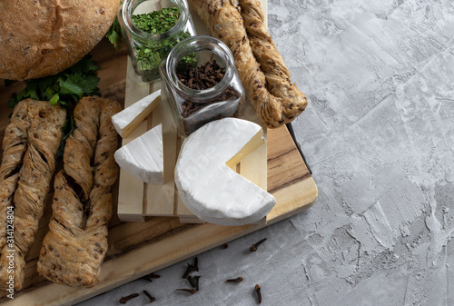 brie cheese with fersh bread and parsley on the grey backgrounnd  photo