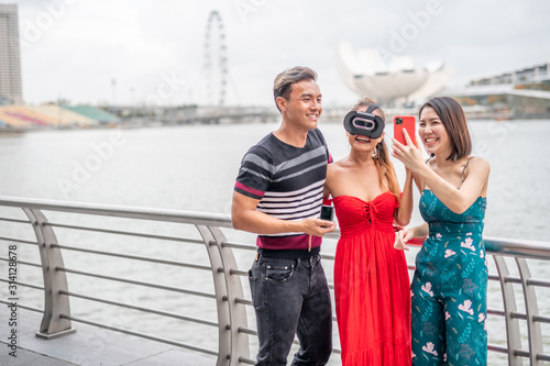 Mixed genders friends outdoor visiting city wearing 3d visor and taking selfies © jovannig