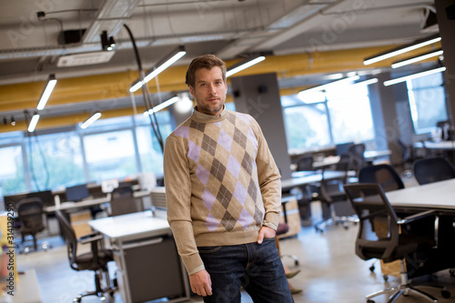 Portrait shot of handsome businessman wearing casual clothes while standing in the office