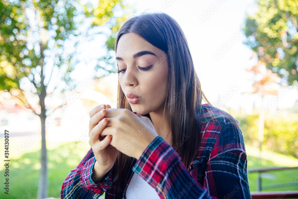 Beautiful young woman drinking coffee outdoors Beautiful young woman drinking coffee outdoors