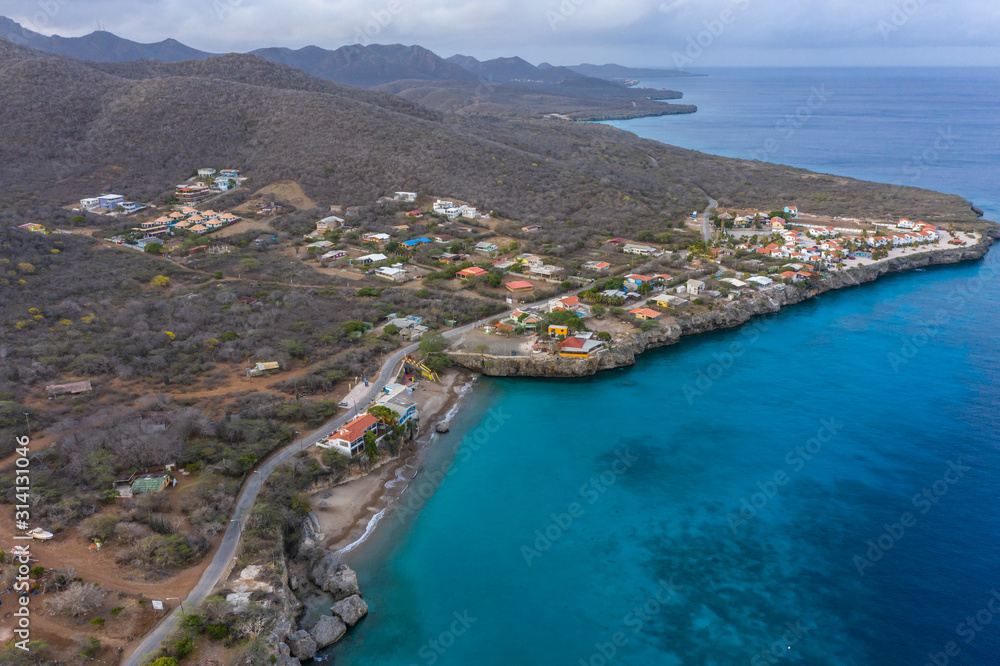 Aerial view of coast of Curaçao in the Caribbean Sea with turquoise water, cliff, beach and beautiful coral reef around Westpunt