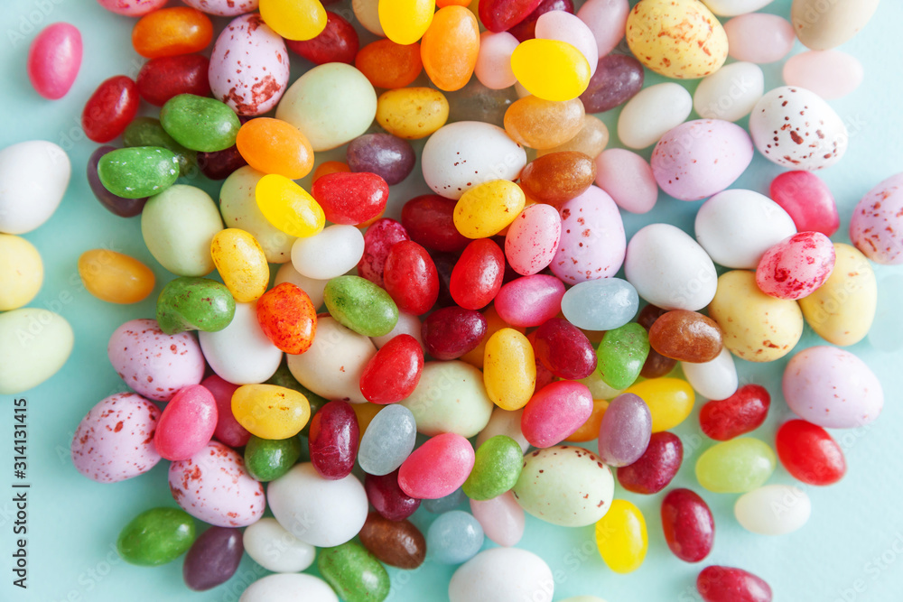 Happy Easter concept. Preparation for holiday. Easter candy chocolate eggs and jellybean sweets isolated on trendy pastel blue background. Simple minimalism flat lay top view copy space. Happy Easter concept. Preparation for holiday. Easter candy chocolate eggs and jellybean sweets isolated on trendy pastel blue background. Simple minimalism flat lay top view copy space.