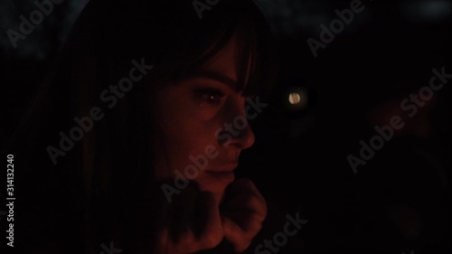Woman Looking at Campfire in the Dark Outside