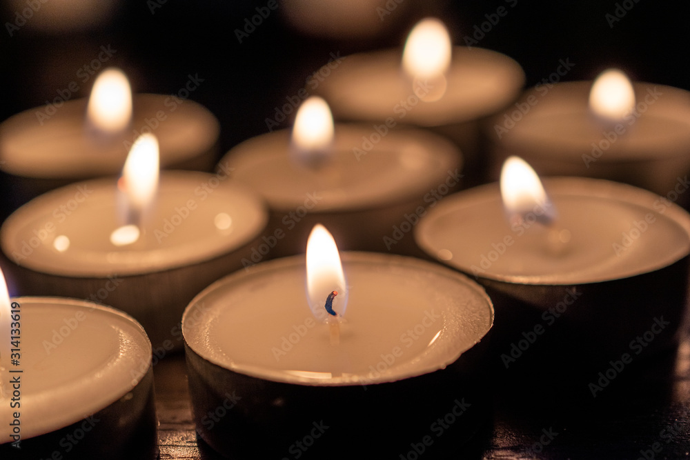 close up of burning candles on black table in the dark. close up of burning candles on black table in the dark.