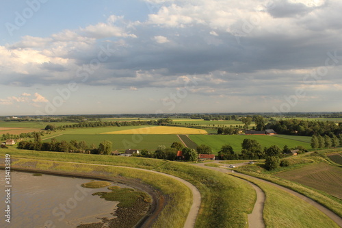 aerial view at the dutch countryside in zeeland along the westerschelde at a sunny day in springtime and beautiful clouds in the sky