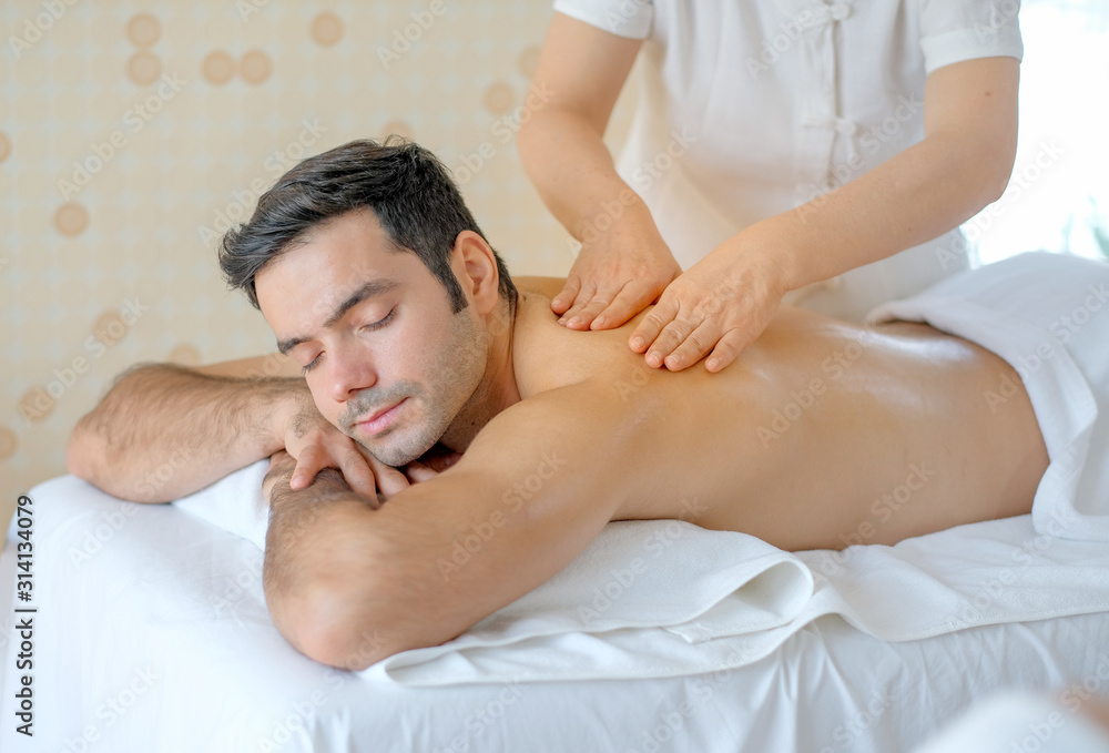 Handsome man enjoy with Thai masseuse massage to him and he lie on bed in  spa room with day light. Stock-foto | Adobe Stock