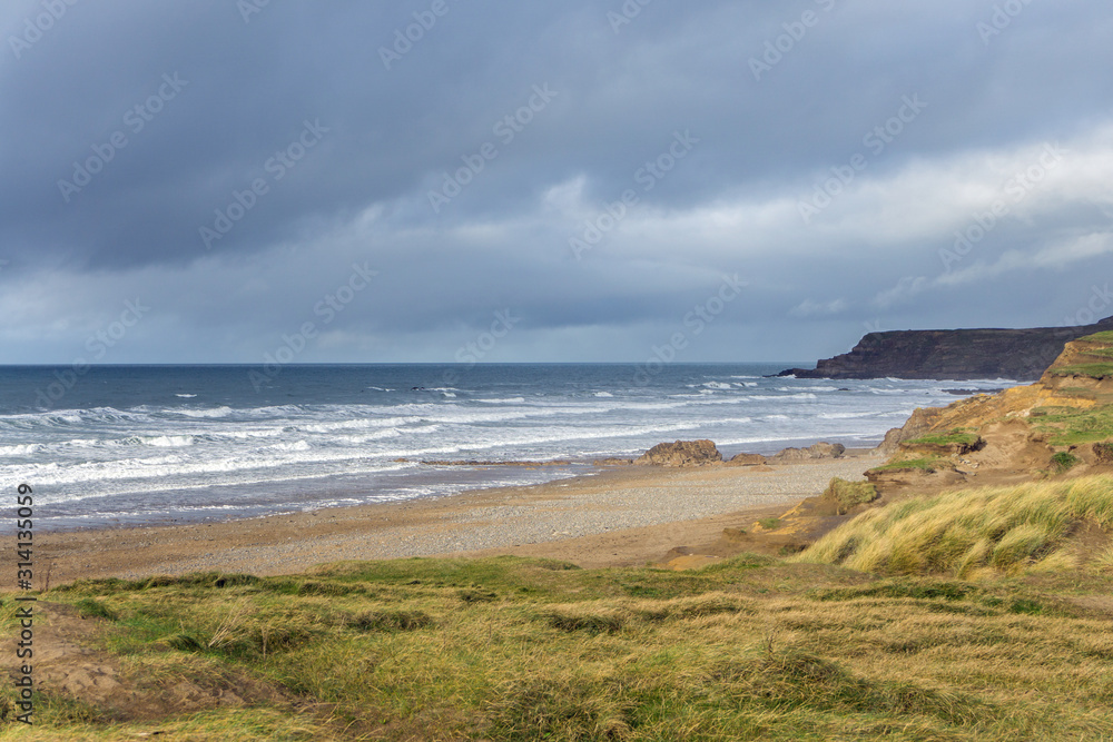 stormy clouds and waves at Widemouth Bay , Bude in Cornwall