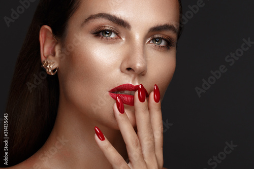 Beautiful girl with a classic make-up and red nails Fototapet