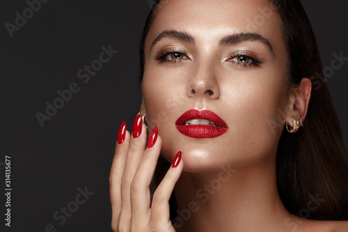 Beautiful girl with a classic make-up and red nails. Manicure design. Beauty face.