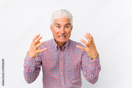 Senior caucasian man isolated upset screaming with tense hands. photo