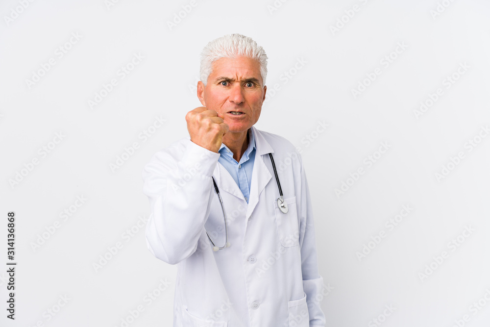 Mature caucasian doctor man showing fist to camera, aggressive facial expression. Mature caucasian doctor man showing fist to camera, aggressive facial expression.
