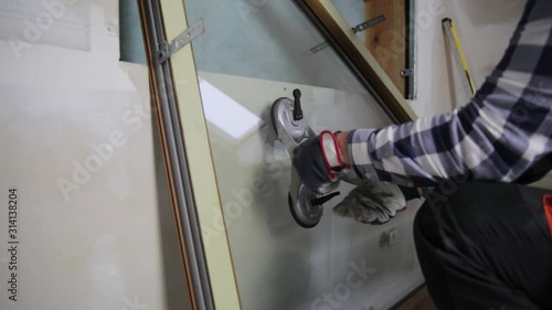 Handyman, construction man installing PVC window in a new insulated and filled dry wall attic.