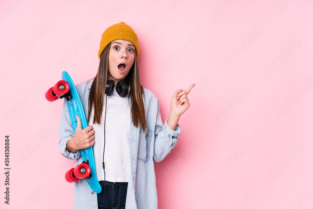 Young skater woman holding a skate pointing to the side Young skater woman holding a skate pointing to the side
