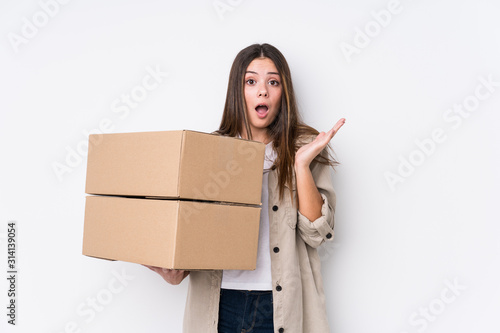 Young caucasian woman moving to a new home surprised and shocked.
