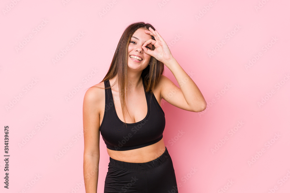 Young fitness caucasian woman isolated excited keeping ok gesture on eye. Young fitness caucasian woman isolated excited keeping ok gesture on eye.