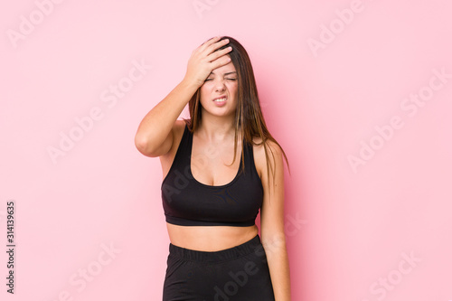 Young fitness caucasian woman isolated forgetting something, slapping forehead with palm and closing eyes. © Asier