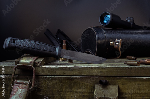 Knife and scope. A large knife and a hunting sight on a war box ..