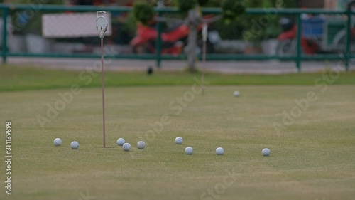 golfer putting golf ball in to the hole
