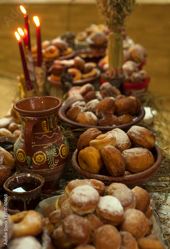 Donuts with icing sugar on a plate. Delicious fried donuts on a Christmas table at holy evening. Christmas traditional food in Ukraine.