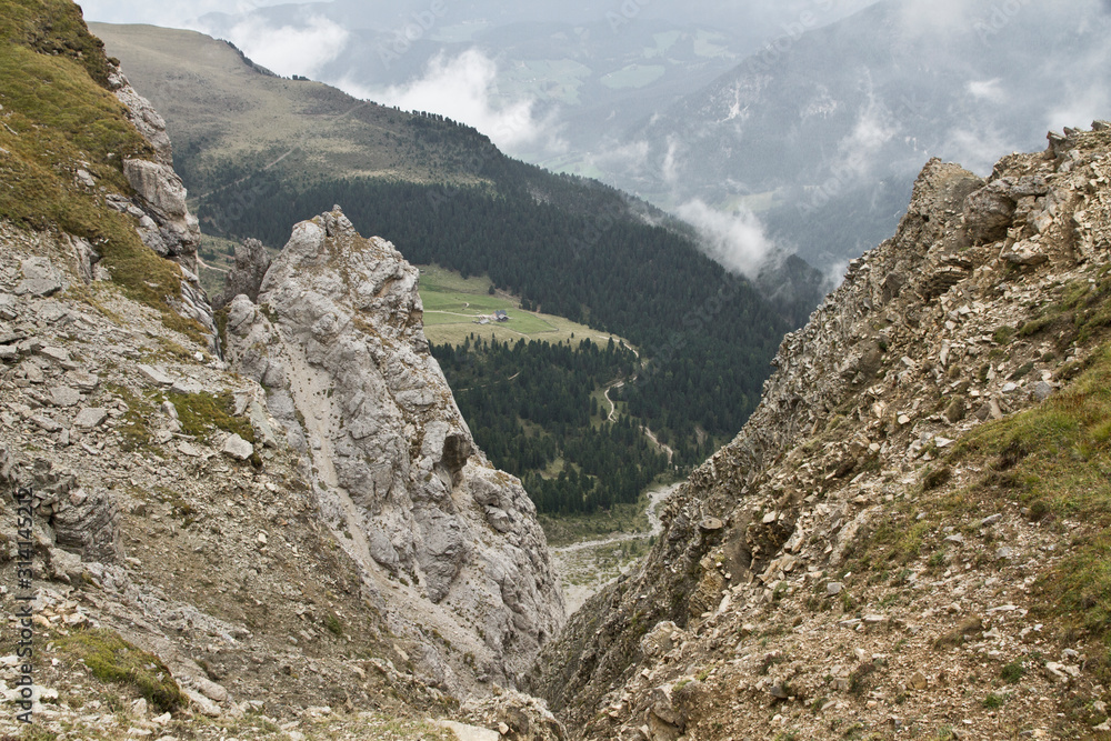 Wanderung im Herbst in den Dolomiten mit schöner Bergkulisse der Seceda im Grödner Tal in Südtirol Italien in Europa. Nebel und Wolken. Wald und Felsen