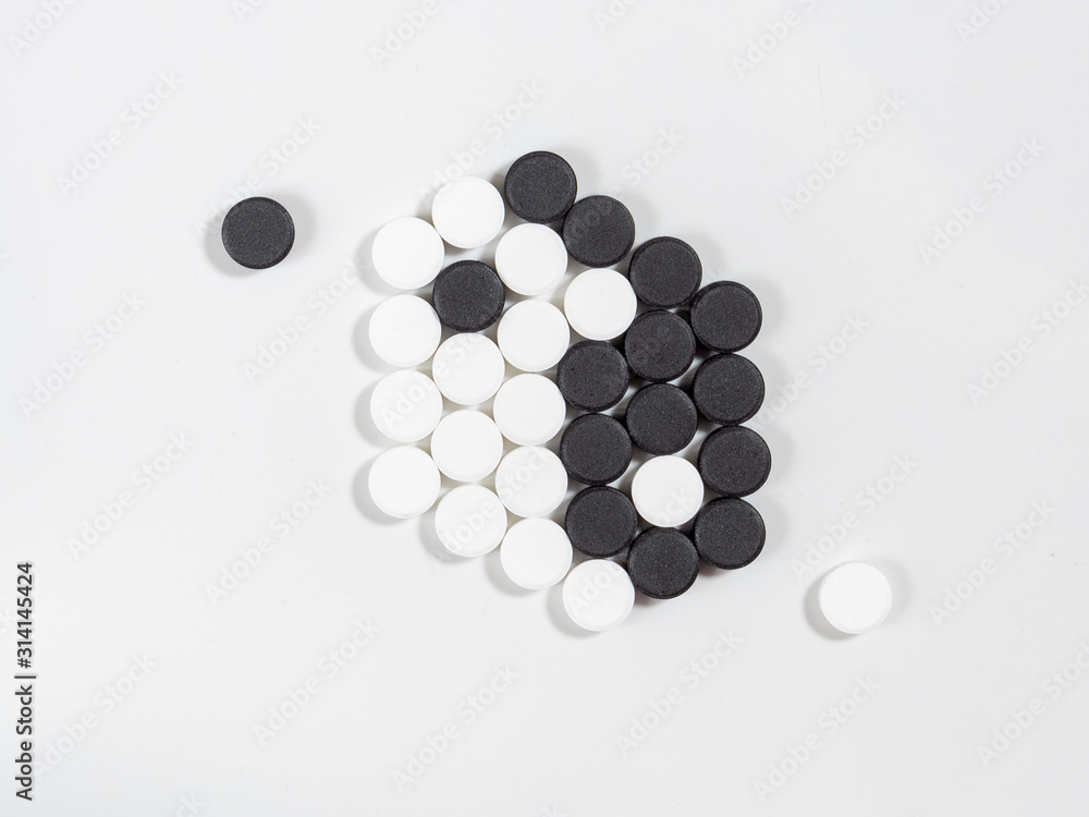 The Ying Yang sign painted on painted on tablets or pills The Ying Yang sign painted on painted on tablets or pills