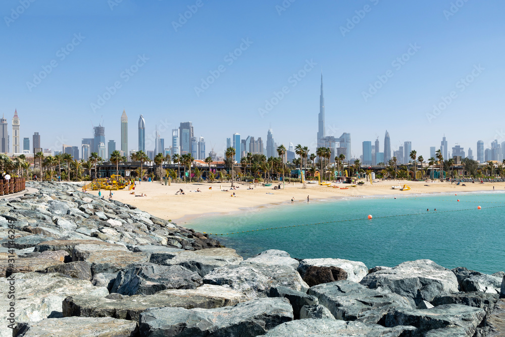 Φωτογραφία Dubai view of La Mer beach, people relax, in the distance the skyscrapers of the city