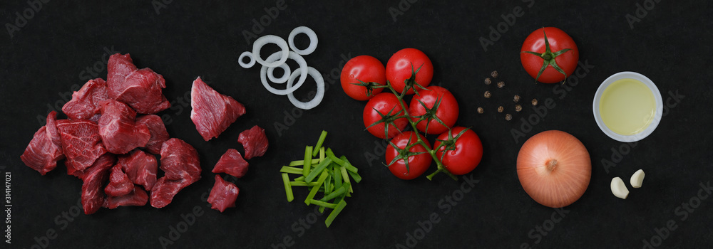 Φωτογραφία GMO free food: tomatoes, beef, onion, garlic, black pepper and bowl with oil on black stone cutting board for cooking beef stew or stir-fry