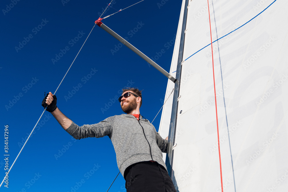 Φωτογραφία Young adult fisherman staying with happy smile on yacht by the sea