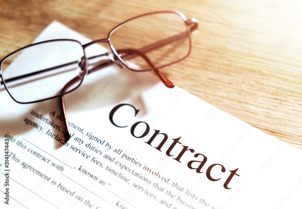 Contract sheet with glasses on a wooden background Contract sheet with glasses on a wooden background