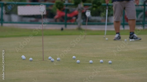 golfer putting golf ball in to the hole