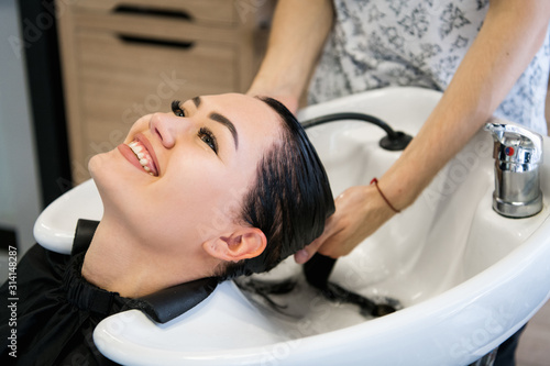 Woman getting hair treatment in a spa salon using shampoo for hair, beauty salon, hair wash