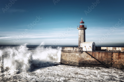 Moleh to Douro lighthouse on the Atlantic Ocean, during a small storm with waves, white lighthouse with a red roof