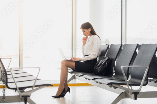 Young lady sitting in a modern cityscape with laptop