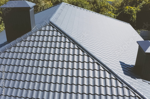 Gray-blue metal roof tiles on the roof of the house. Corrugated photo