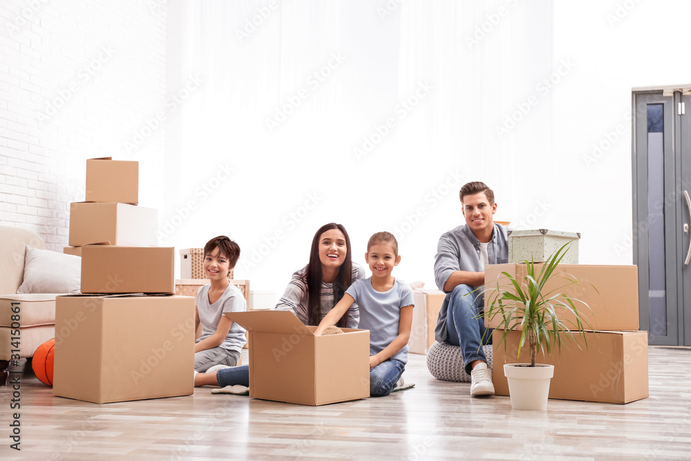 Happy family unpacking moving boxes at their new home Happy family unpacking moving boxes at their new home