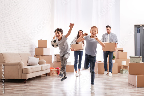 Happy family in room with cardboard boxes on moving day photo