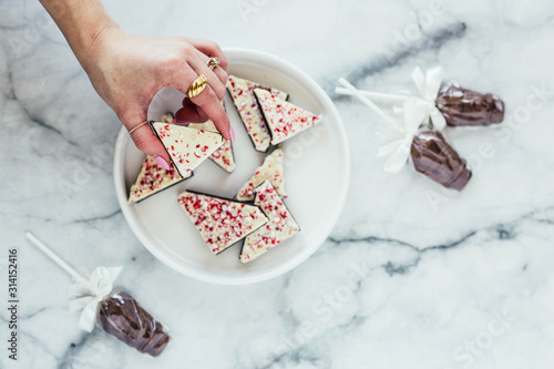 Peppermint white chocolate bark and chocolate suckers on marble background photo