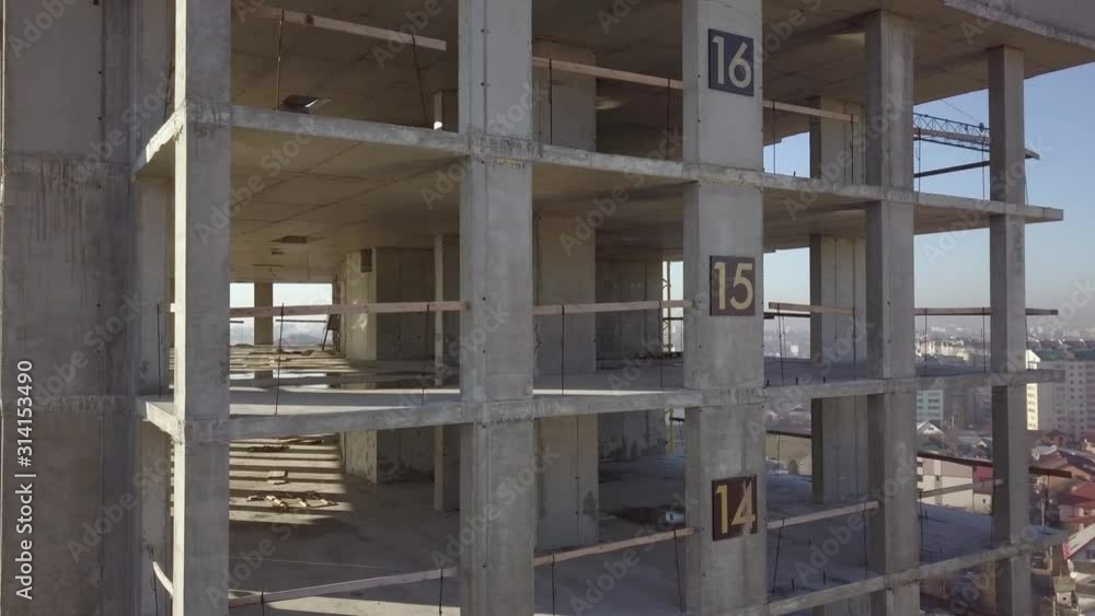 Aerial view of concrete frame of tall apartment building under construction in a city. Aerial view of concrete frame of tall apartment building under construction in a city.