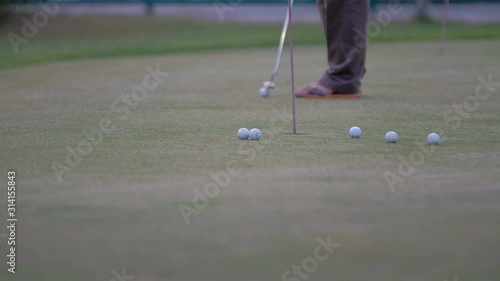 golfer putting golf ball in to the hole