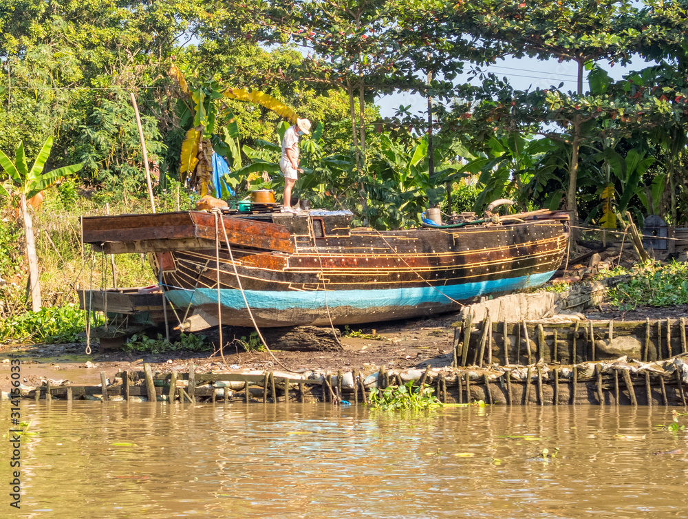 Traditional Mekong Delta freight boat under repair - Vinh Long, Vietnam Traditional Mekong Delta freight boat under repair - Vinh Long, Vietnam