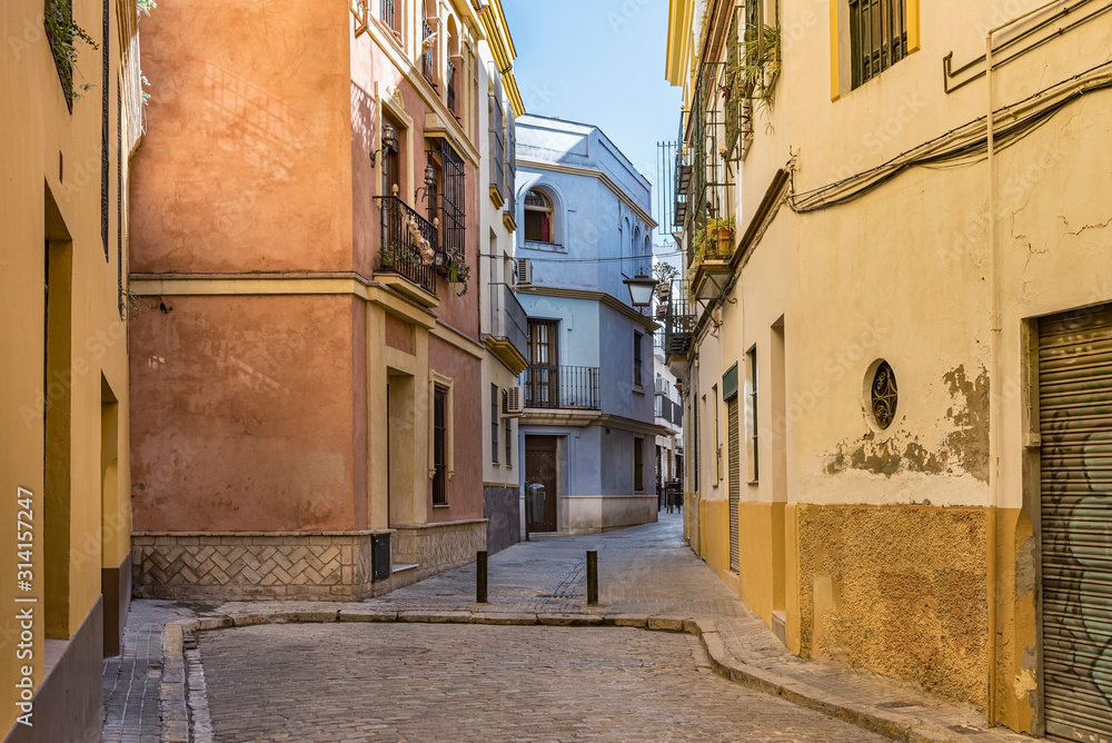 Fototapeta premium Colorful street in the old town of Seville, Spain. Nice Spanish alley among this Andalusian road