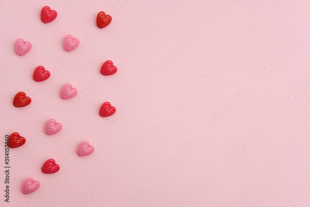 Red and pink heart beads shape - top view / flat lay with pink background