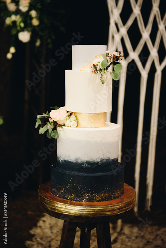 Beautiful elegant modern wedding cake with golden coating outside