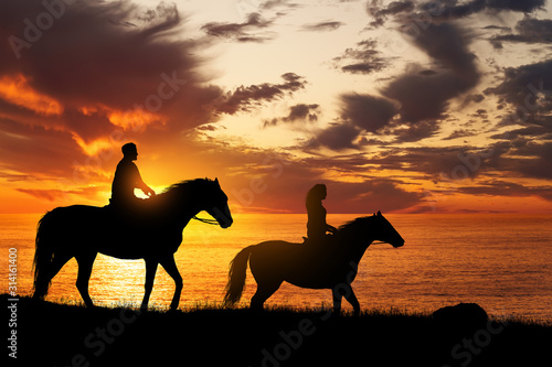 Couple on horseback at sunset