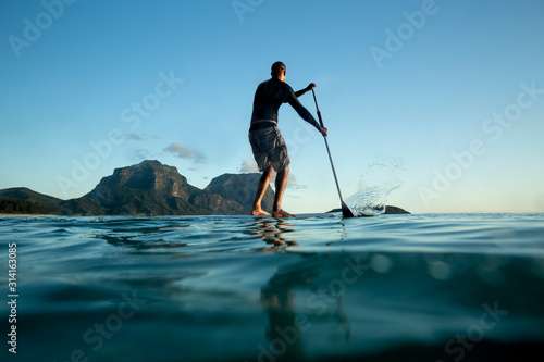 man Stand Up paddle boarding on Calm sea water Lord Howe Island