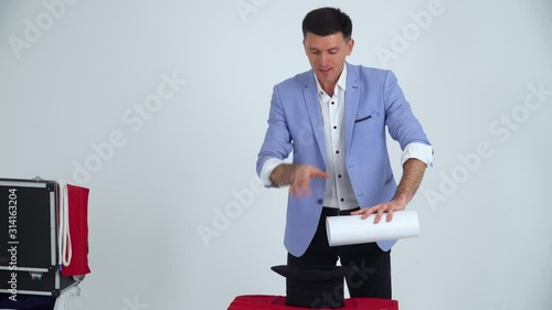 Magician in a suit shows a trick with money on a white background photo